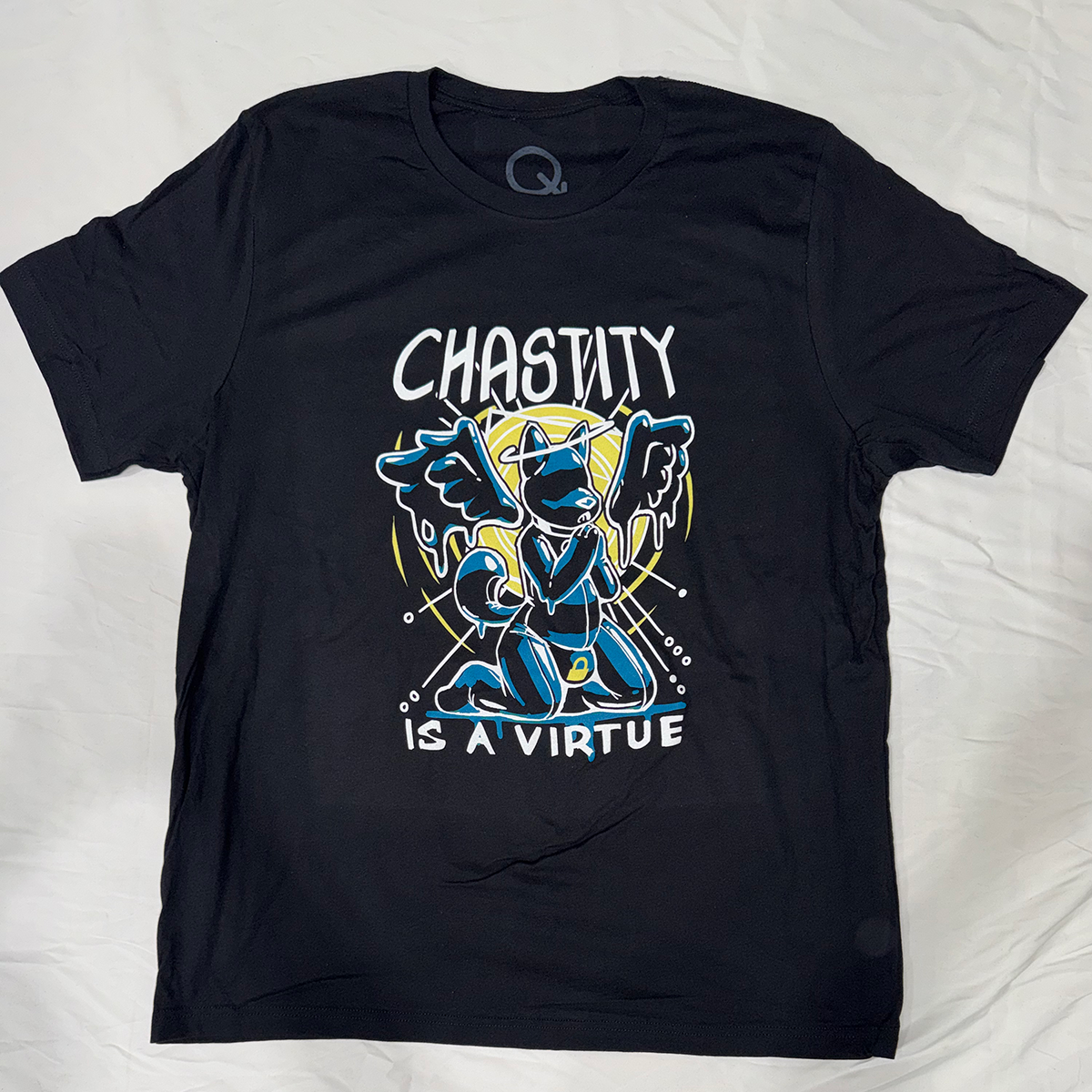 Black screen printed t-shirt with an illustration of a rubber creature with wings and halo iconography. Text reading; "Chastity is a Virtue," in the background.